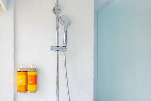 a bathroom with two shower heads on a wall at 苓旅松山館 Lininn Tapei Arena in Taipei