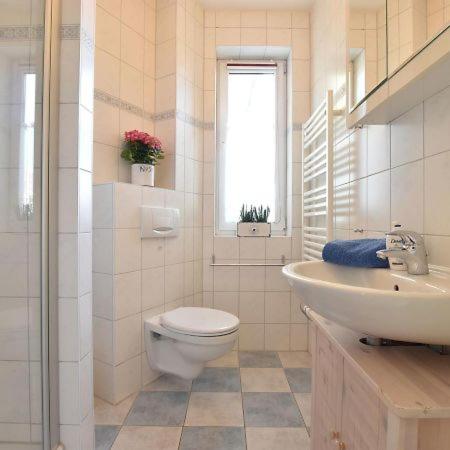 a white bathroom with a toilet and a sink at Ferienwohnung Klast F51 in Kühlungsborn