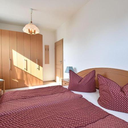 a bedroom with a large red bed with purple pillows at Ferienwohnung Klast F51 in Kühlungsborn