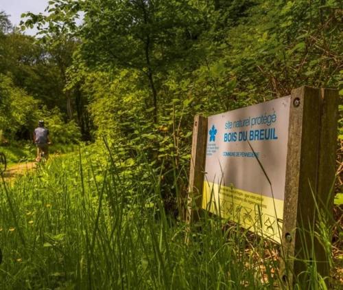 a sign in the grass with a person in the background at Studio du Mesnil in Équemauville