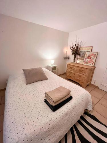 une chambre avec un lit avec deux serviettes dessus dans l'établissement Studio du Mesnil, à Équemauville