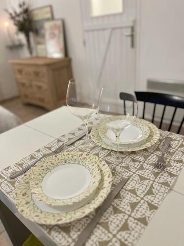 - une table avec deux assiettes et des verres à vin dans l'établissement Studio du Mesnil, à Équemauville