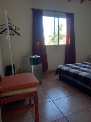 une chambre avec un lit, une télévision et une fenêtre dans l'établissement Alojamiento temporario 2, à Lanús