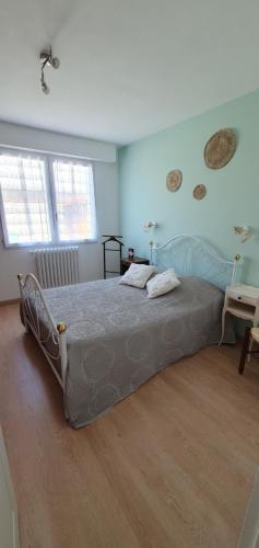 une chambre avec un grand lit dans une pièce dans l'établissement Jolie Maison de Vacances, à Les Sables-dʼOlonne