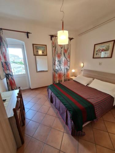 a bedroom with a large bed and a window at Albergo Genio in Portovenere