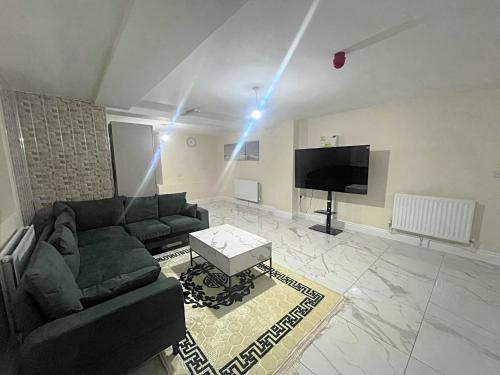 a living room with a couch and a tv at Modern Flat near StarCity, Bull Ring & M6 in Birmingham