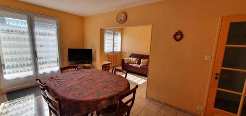 un salon avec une table et un canapé dans l'établissement Jolie Maison de Vacances, à Les Sables-dʼOlonne