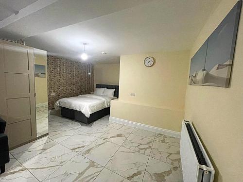 a bedroom with a bed and a clock on the wall at Modern Flat near StarCity, Bull Ring & M6 in Birmingham