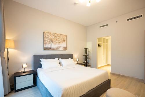a bedroom with a large white bed in a room at Ferrari World & Seaworld - Luxe 2bhk Canal View in Yas Island