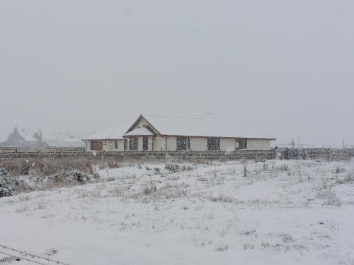 an old building in a field in the snow at Scorrybreac B&B in Broadford