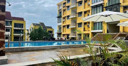 a swimming pool in front of some apartment buildings at Kudrats Vintage Loft - Sea & Island view Retreat in Canacona