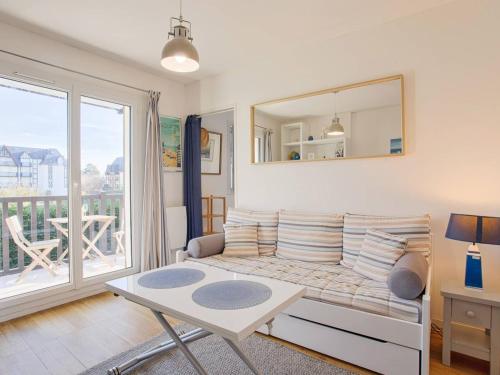 un salon avec un lit et une grande fenêtre dans l'établissement Appartement à Cabourg avec balcon et parking, proche mer - FR-1-788-41, à Cabourg