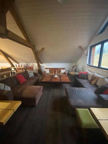 - un salon mansardé avec des canapés et une table dans l'établissement Lysgaardcottage 360 sauna spa bar Dancing 25V, à La Bresse