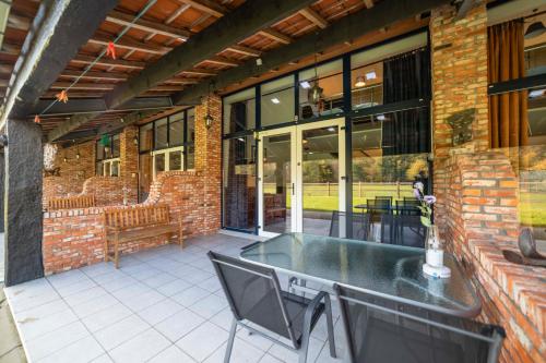 a patio with a table and chairs on a brick building at B&B De Kroonhoeve in Beringen