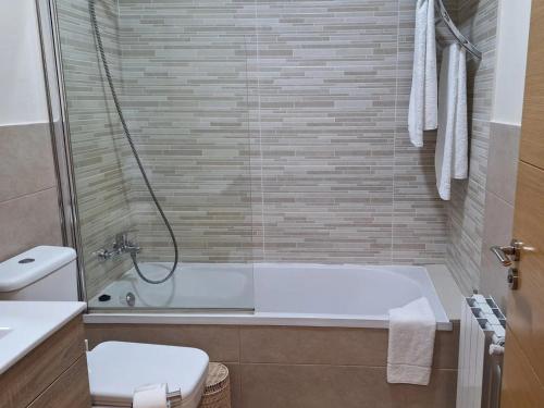 ein Badezimmer mit Badewanne, Toilette und Dusche in der Unterkunft APARTAMENTOS COSTA XUÑO in Porto do Son