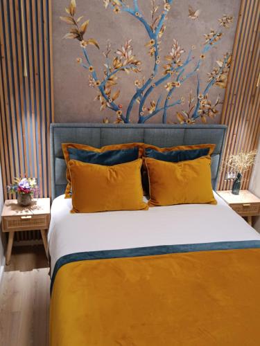 a bedroom with a large bed with yellow pillows at Filoxenia Luxury Apartment in Nafplio