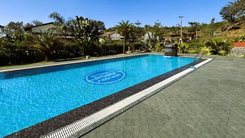 a swimming pool in a house with a blue at Hong Sau Resort in Sakleshpur