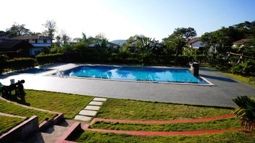 a swimming pool in the middle of a yard at Hong Sau Resort in Sakleshpur
