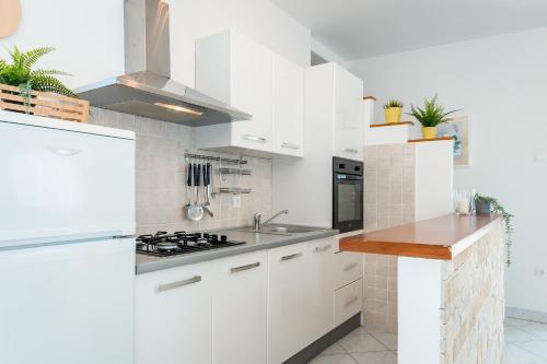 a white kitchen with white cabinets and a sink at Jadrija Bay in Šibenik