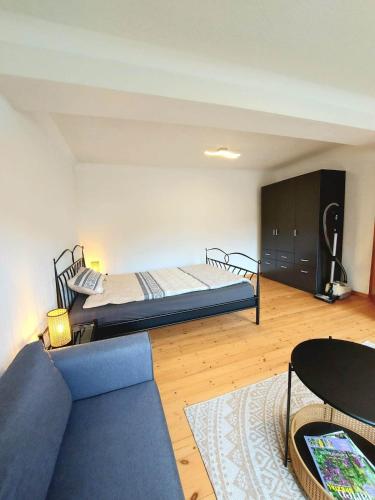 a living room with a bed and a couch at Ferienwohnung auf Hof Santangelo in Dickesbach
