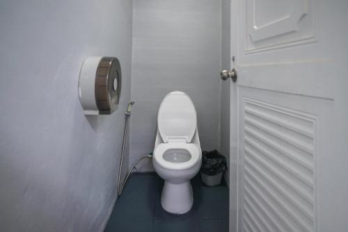 a white toilet in a bathroom with a door at ปางสูงเฮาส์ pangsung house บ้านมินิ เหลือง in Ban Pang Bo Hu Bon