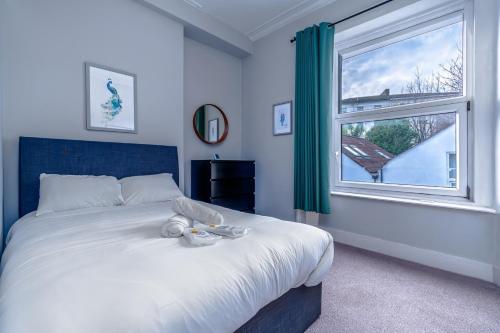 a bedroom with a large bed and a window at Artful flat with skyline view, Stokes Croft in Bristol