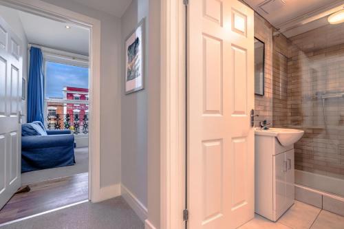 a bathroom with a white door and a sink at Artful flat with skyline view, Stokes Croft in Bristol
