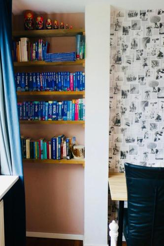 a book shelf filled with books next to a desk at Silver Moon Bed & Breakfast in Voorschoten