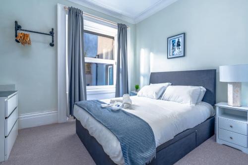 a bedroom with a bed with a teddy bear on it at Stylish city view flat in mural quarter in Bristol