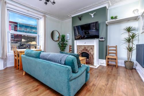 a living room with a blue couch and a fireplace at Stylish city view flat in mural quarter in Bristol