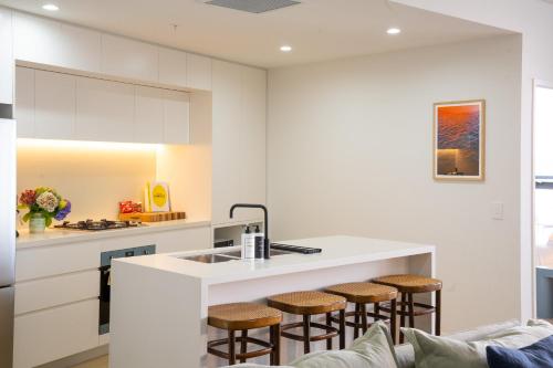 a kitchen with a kitchen island with bar stools at Executive Rental - Campbelltown in Campbelltown
