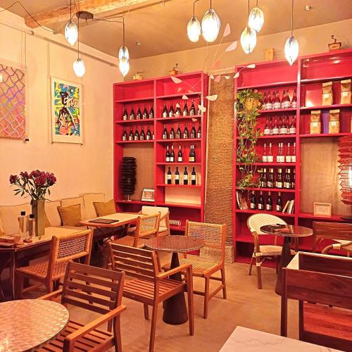 een restaurant met tafels en stoelen en wijnflessen bij LA MAISON VERTE SETE in Sète