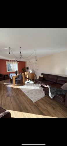 un salon avec un canapé et une table dans l'établissement Maison de la forêt, à Auxonne