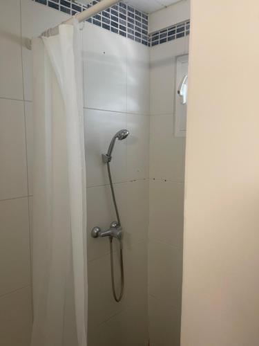a shower stall with a shower curtain in a bathroom at Bungalows MALUEVA PREMIUM 1 chambre et 1 mezzanine à 5min de la plage de la Caravelle in Sainte-Anne