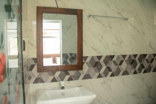 a bathroom with a sink and a mirror at Methu Villa in Ahangama