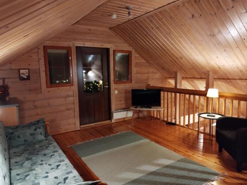 un soggiorno con un divano e una televisione di Vihreä Helmi a Kuusamo