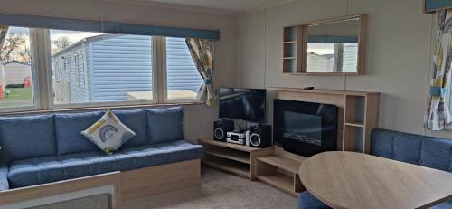 a living room with a blue couch and a tv at Billing Aquadrome, Horizon 3 Bedrooms, BLP 17A in Northampton