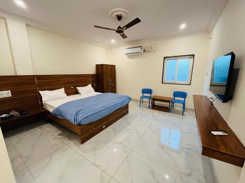 a bedroom with a bed and a ceiling fan at Blue Waves Beach Resort in Vetāpālem