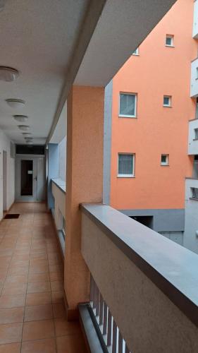 an empty hallway of a building with orange at Nelli apartman free parking in Šamorín