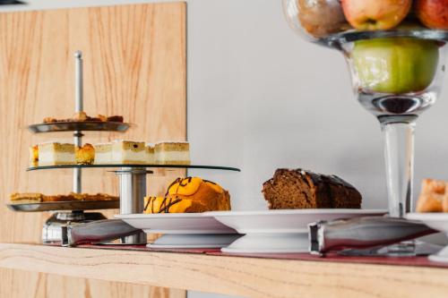 a table with cakes and other desserts on plates at Neco Boutique Hotel in San Bernardo