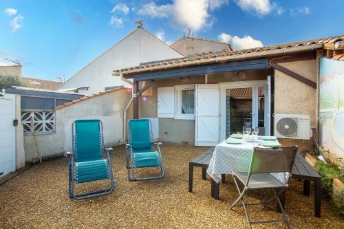 une terrasse avec une table et des chaises ainsi qu'une maison dans l'établissement La Casa Di Benedetta, à Portiragnes