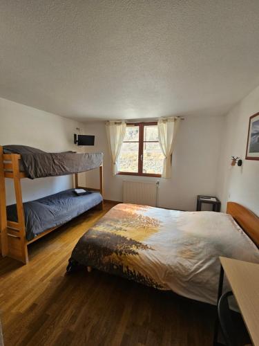 a bedroom with two bunk beds and a desk at Le Campcardos in Porta
