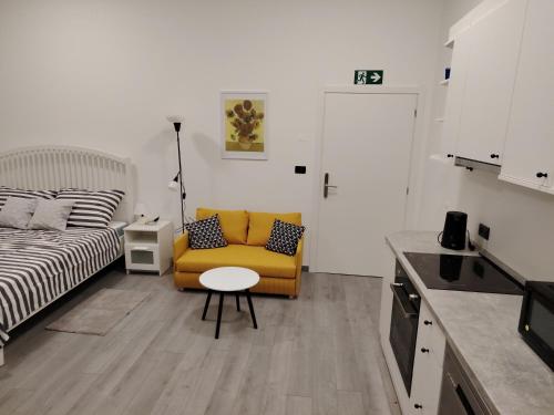 Una sala de estar con una silla amarilla y una cama. en Studio apartment Andre, en Rijeka