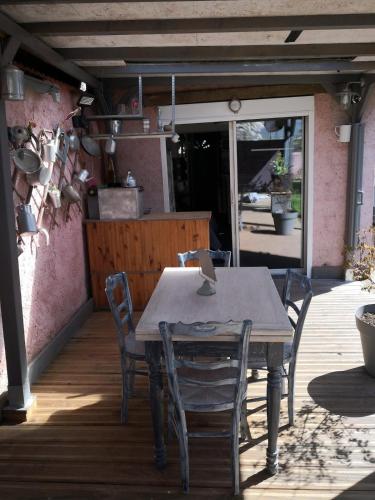 a wooden table and chairs on a patio at JOLI COCON AVEC TERRASSE ENTRE GIVERNY et LA ROCHE GUYON in Gasny