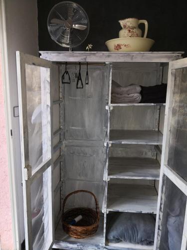 an old wooden shelf with a fan and a basket at JOLI COCON AVEC TERRASSE ENTRE GIVERNY et LA ROCHE GUYON in Gasny