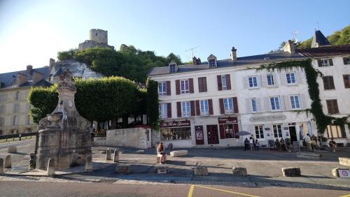 a woman standing next to a fountain in front of a building at JOLI COCON AVEC TERRASSE ENTRE GIVERNY et LA ROCHE GUYON in Gasny