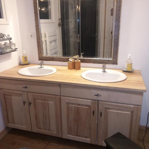 une salle de bain avec deux lavabos et un grand miroir dans l'établissement maison calme et campagne, à Le Pin-la-Garenne