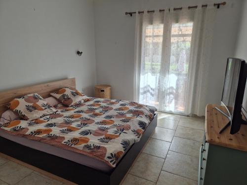 une chambre avec un lit, une télévision et une fenêtre dans l'établissement Villa la Cigaline, à Lauris