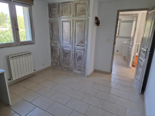 une pièce avec une grande armoire en bois et un sol carrelé dans l'établissement Villa la Cigaline, à Lauris