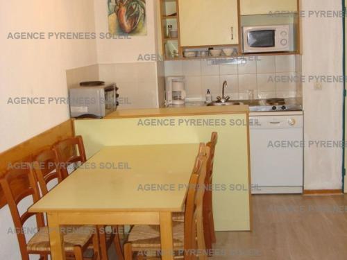 a kitchen with a table and chairs in a room at Appartement familial, 2 chambres, balcon S-E, à 30m pistes et Balnéo, Les Angles - FR-1-295-135 in Les Angles